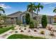 Charming single-story home with lush tropical landscaping, stone pathway, and a vibrant turquoise front door at 6113 55Th E Ter, Bradenton, FL 34203