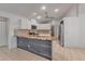 Bright kitchen boasts white cabinets, stainless appliances, and a large island with stone countertops at 6113 55Th E Ter, Bradenton, FL 34203