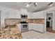 Well-lit kitchen with stainless appliances, granite countertops, and white cabinetry at 6113 55Th E Ter, Bradenton, FL 34203