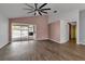 Open floor plan with wood-look flooring, ceiling fan, and view to the pool at 6113 55Th E Ter, Bradenton, FL 34203