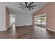 Spacious living room with a ceiling fan, wood-look flooring and sliding glass doors at 6113 55Th E Ter, Bradenton, FL 34203