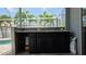 Outdoor kitchen with black cabinets, granite countertops, mosaic backsplash and view of palm trees at 6113 55Th E Ter, Bradenton, FL 34203