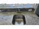 Close-up of the outdoor kitchen sink with a granite countertop and mosaic tile backsplash at 6113 55Th E Ter, Bradenton, FL 34203