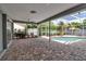 Spacious screened-in lanai with ceiling fan, brick flooring, and a view of the inviting pool at 6113 55Th E Ter, Bradenton, FL 34203