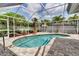 Screened-in kidney-shaped pool and patio, surrounded by mature trees and palm trees, for private relaxation at 6113 55Th E Ter, Bradenton, FL 34203