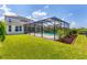 A screened-in pool and large grass yard behind a beautiful home at 6125 Anise Dr, Sarasota, FL 34238