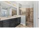 Bathroom with double vanity, glass enclosed shower, and neutral tile at 6125 Anise Dr, Sarasota, FL 34238
