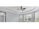 Bedroom featuring tray ceiling, ceiling fan, and large windows at 6125 Anise Dr, Sarasota, FL 34238