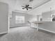 Bonus room featuring built-in shelves, carpet, and tray ceiling with ceiling fan at 6125 Anise Dr, Sarasota, FL 34238