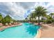 A beautiful community pool surrounded by lounge chairs and palm trees on a sunny day at 6125 Anise Dr, Sarasota, FL 34238