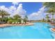 A beautiful community pool surrounded by lounge chairs and palm trees on a sunny day at 6125 Anise Dr, Sarasota, FL 34238