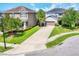 Charming two-story home boasts a well-manicured lawn and a long driveway leading to an attached two-car garage at 6125 Anise Dr, Sarasota, FL 34238