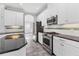 Well-equipped kitchen boasts stainless steel appliances, white cabinetry and black countertops at 6125 Anise Dr, Sarasota, FL 34238