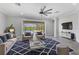 Comfortable living room with a large ceiling fan and view of the screened-in pool area at 6125 Anise Dr, Sarasota, FL 34238