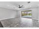 Spacious living room area with tile flooring, a ceiling fan, and sliding glass doors to the pool at 6125 Anise Dr, Sarasota, FL 34238