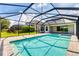 Screened-in pool area with a stone-paved patio and view of manicured lawn and green foliage at 6125 Anise Dr, Sarasota, FL 34238