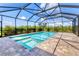 Screened-in pool with a shallow step-in area, surrounded by brick pavers at 6125 Anise Dr, Sarasota, FL 34238