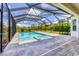 Screened-in pool area with a stone-paved patio and a view of the well-kept backyard at 6125 Anise Dr, Sarasota, FL 34238