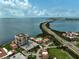 An aerial view features condo buildings, a pool, and a scenic causeway by the water at 6372 Palma Del Mar S Blvd # 503, St Petersburg, FL 33715