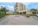 A multi-story condo building with a covered parking area and tropical landscaping at 6372 Palma Del Mar S Blvd # 503, St Petersburg, FL 33715