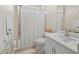 Well-lit bathroom featuring a white vanity, toilet, tub, and a shower behind a white curtain at 6643 Butlers Crest Dr, Bradenton, FL 34203