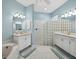Inviting bathroom with double sinks, tub, glass block shower and blue accent wall at 6643 Butlers Crest Dr, Bradenton, FL 34203