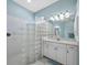 Bright bathroom featuring a glass block shower wall, white vanity, and ample lighting, offering a modern aesthetic at 6643 Butlers Crest Dr, Bradenton, FL 34203