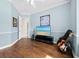 Inviting bedroom with hardwood floors, featuring a TV, guitars, and tranquil beach painting art on the wall at 6643 Butlers Crest Dr, Bradenton, FL 34203