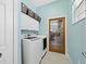 Bright laundry room with a door leading to the garage, white cabinets, and modern appliances at 6643 Butlers Crest Dr, Bradenton, FL 34203