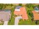 An aerial view of a well-maintained home features a pristine yard, screened pool, and circular driveway at 7804 Broadmoor Pines Blvd, Sarasota, FL 34243