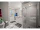 Bathroom featuring white vanity, shower with glass door, and tiled floors and walls at 7804 Broadmoor Pines Blvd, Sarasota, FL 34243