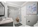 Well-lit bathroom features a modern shower, granite countertops, and a beach-themed painting at 7804 Broadmoor Pines Blvd, Sarasota, FL 34243
