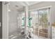 Modern bathroom featuring a frameless glass shower with a pebble floor and a sliding glass door to the backyard at 7804 Broadmoor Pines Blvd, Sarasota, FL 34243