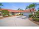 Lovely single-story home boasts a red-tile roof, mature landscaping, and an attached two-car garage at 7804 Broadmoor Pines Blvd, Sarasota, FL 34243