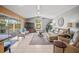 Bright living room featuring a vaulted ceiling, tile flooring, and sliding glass doors to the outdoor living space at 7804 Broadmoor Pines Blvd, Sarasota, FL 34243