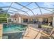 Inviting screened-in pool area with patio seating and tile roof home at 7804 Broadmoor Pines Blvd, Sarasota, FL 34243