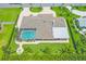 An aerial view of the property, boasting a large screened pool, fire pit, and circular driveway at 7913 19Th Avenue W Dr, Bradenton, FL 34209
