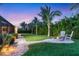 Enjoy outdoor living with a charming fire pit area nestled in a lush backyard with tropical plants and swaying palm trees at 7913 19Th Avenue W Dr, Bradenton, FL 34209