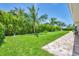 Green backyard with lush landscaping and walkway on side of the home at 7913 19Th Avenue W Dr, Bradenton, FL 34209