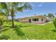 Expansive backyard featuring lush green grass and mature palm trees with a view of the pool at 7913 19Th Avenue W Dr, Bradenton, FL 34209