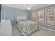 Bright bedroom with blue walls, white trim, wood blinds, and patterned bedding at 7913 19Th Avenue W Dr, Bradenton, FL 34209