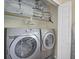 Laundry room with front-loading washer and dryer, shelves with pillows and comforters, and a folding door at 7913 19Th Avenue W Dr, Bradenton, FL 34209