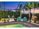 Relaxing pool area with screened enclosure, colorful Adirondack chairs, and tropical landscaping at 7913 19Th Avenue W Dr, Bradenton, FL 34209