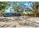 Backyard featuring a gravel area, a screened-in porch, and mature shade trees for outdoor enjoyment at 8234 Midnight Pass Rd, Sarasota, FL 34242