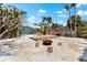 Spacious backyard with a firepit, pool, deck, and white gravel at 8234 Midnight Pass Rd, Sarasota, FL 34242