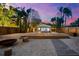 Backyard features a modern pool with a spacious wood deck and stone walkway under a twilight sky at 8234 Midnight Pass Rd, Sarasota, FL 34242