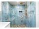 Walk-in shower featuring pebble floor and striking blue marble-look tile at 8234 Midnight Pass Rd, Sarasota, FL 34242