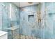 Walk-in shower featuring pebble floor and striking blue marble-look tile at 8234 Midnight Pass Rd, Sarasota, FL 34242
