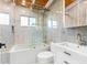 Bright bathroom featuring modern tub-shower combo, white vanity, and eye-catching hexagon tile floor and accent wall at 8234 Midnight Pass Rd, Sarasota, FL 34242