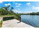 Scenic waterfront view showcasing a wooden dock surrounded by lush greenery and tranquil waters at 8234 Midnight Pass Rd, Sarasota, FL 34242